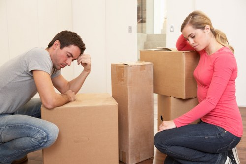 Movers carrying household items from a London flat with stair access
